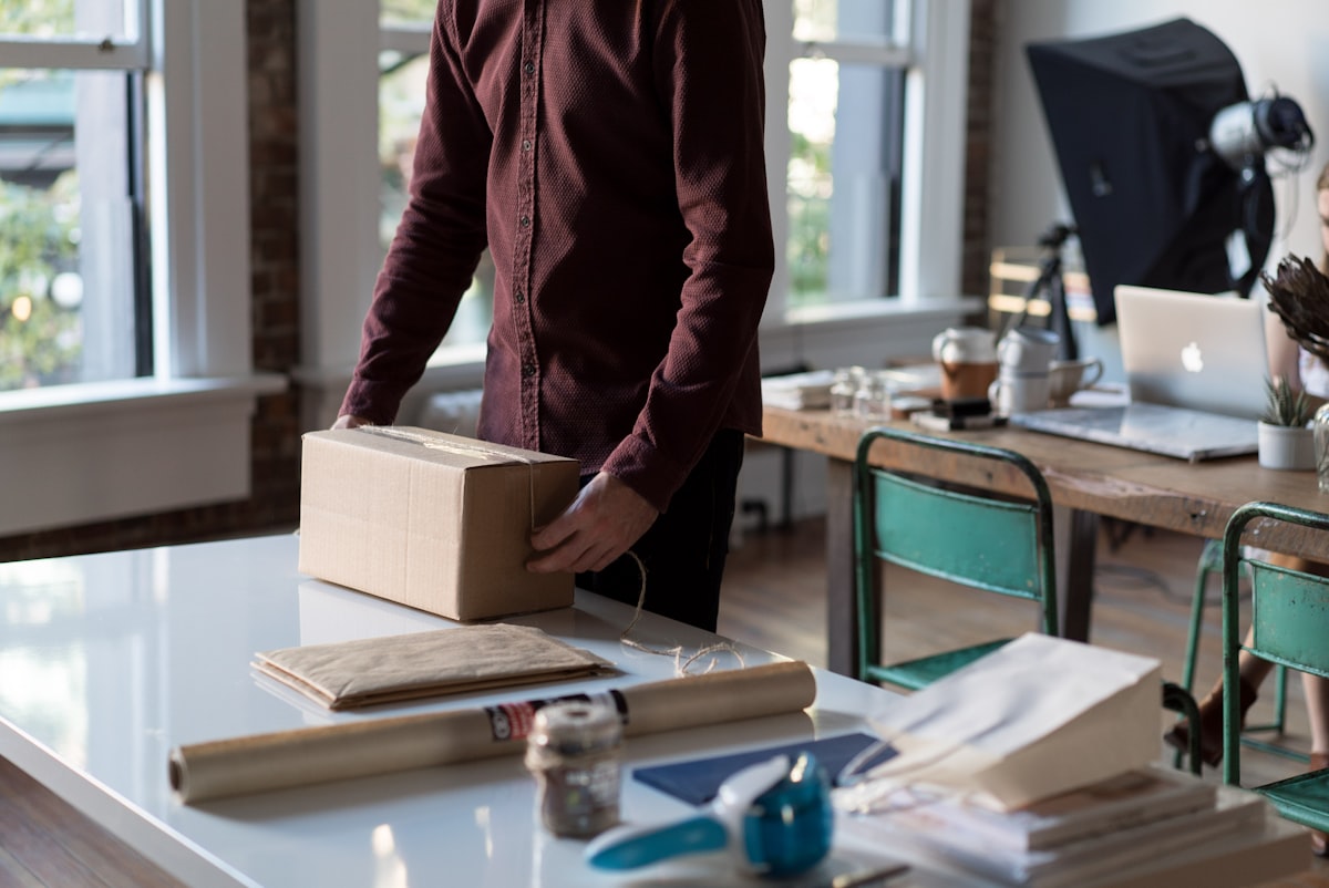 Small business owner packing an e-commerce order in a modern workspace